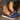 Women's brown wedge loafers styled as casual sneakers, shown with denim jeans.