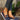Women's brown wedge loafers worn by a person standing on grass, with blue denim jeans visible.