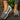 Women's brown wedge loafers styled as casual sneakers on a model, showcasing the shoe's sleek design and comfortable fit.