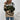 Women's camouflage knit sweater in green, black, and beige featuring a street style design with long sleeves, a round neck, and a stylish fit that reaches the waist.
