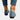 Women's blue denim flats featuring a stylish chain ankle bracelet, shown on feet wearing jeans.
