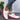 Women's floral mesh sneakers featuring a pink sole, designed for lightweight and breathable comfort, shown on a model's foot.