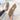 A pair of women's fluffy slippers with a plush, soft texture, designed for non-slip wear. The slippers offer warm comfort suitable for winter. They are displayed on a wooden surface, highlighting their cozy and inviting appearance.