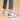 Women's grey casual sneakers with purple accents and a pink heel, worn with denim jeans.