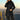 Women's grey waterproof hooded raincoat with lightweight design, featuring a person standing outdoors wearing sunglasses, showcasing urban style with a sleek overcoat and long sleeves.