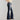 A pair of women's high-waist dark wash flared stretch jeans being worn, highlighting the waist and leg fit with a flared design at the bottom.