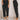 A woman is modeling high-waisted terracotta corduroy cropped pants. The pants are styled with a high waist and a cropped length, showcasing a trendy and fashionable appearance. The model is standing with a white and black outfit, emphasizing the pants' textured and stylish look.