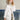 Women's luxury white puffer jacket with a fur hood, showcasing a stylish fashion design, long sleeves, and a defined waist. The coat is made with natural materials, emphasizing the plush fur trim around the collar.