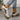 Women's navy fashion sneakers with gold anklet detailing, styled with black outerwear and a chic dress, showcasing an urban fashion look.