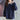 Women's navy blue pullover sweater with contrast white collar, featuring long sleeves and a front pocket.