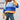 Oversized pastel striped knit sweater in aqua and purple worn with jeans, featuring long sleeves and a cozy, comfortable fit.