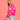 Pink heart-patterned fuzzy knit cardigan worn by a woman, paired with jeans and sunglasses, showcasing a trendy and cozy fashion statement.