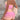 A woman wearing a trendy beach outfit consisting of a pink strapless top and matching high-waisted shorts.