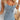 Sleeveless light wash denim bodycon midi dress for women, showing details like the fitted design and medium length, worn by a model with long hair, revealing shoulders and arms.