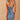 Sleeveless light wash denim bodycon midi dress worn by a woman, showcasing the fitted design with a focus on the shoulders, waist, and neckline.