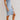 Women's sleeveless light wash denim bodycon midi dress displayed on a model, showcasing a form-fitting sheath silhouette with a casual yet stylish appearance.