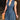 Women's sleeveless V-neck belted denim dress featuring pockets, highlighting its fitted waist and knee-length design.