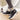 Women's stylish pink high-top sneakers worn on feet, with a focus on the trendy and comfortable design, set against a wooden floor background.