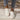 Women's stylish white lace-up sneakers, comfortable low-top trainers shown on feet with jeans.