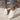 Women's stylish white lace-up sneakers, comfortable low-top trainers, displayed on a model wearing a grey dress. White sneakers with black accents.