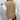 Women's tan cable knit sweater vest featuring a sleeveless design and V-neck style in a woolen texture with intricate patterns.