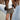 Women's tan fringed suede jacket in a boho chic style, showcasing its soft suede texture and stylish fringe detailing. The jacket is worn by a model, emphasizing the shoulder and sleeve design, perfect for layering in fashion-forward outfits.