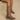 Women's tan leather mid-calf cowboy boots with intricate embroidery and chunky heels, worn by a model showcasing the boots from the knee down.