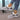Women's turquoise slip-on shoes with fur lining, designed for winter wear, shown on a model wearing a grey dress.