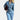 A women's vintage denim jumpsuit featuring a fitted design with long sleeves and pockets, shown in a greyish tone. The jumpsuit has a classic style, emphasizing the waist, and is suitable for casual or semi-formal wear.