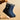 Women's waterproof insulated snow boots in electric blue, featuring a non-slip sole, thermal insulation, and a durable design. The image captures a close-up of a person's lower legs and hands, showcasing the boots' stylish pattern and protective features.