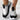 Women's white and black knit slip-on sneakers, featuring a breathable and lightweight design suitable for sportswear.