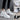 Women's white ankle winter boots with fur lining, lace-up design, and a black sole.