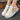 Women's white lace-up sneakers with a stylish low-top design and durable sole, displayed against a plain background.
