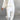 Women's white lounge set featuring a minimalist sweatshirt with long sleeves and relaxed joggers, showcasing a comfortable and stylish design.