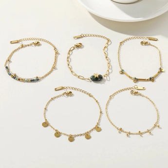 18K Gold Plated Stainless Steel Charm Bracelet by YA-CHAN Jewelry placed on a white surface, with a coffee cup and dishware in the background