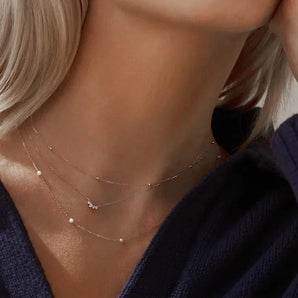 Elegant woman wearing a gold-plated, hypoallergenic 925 sterling silver pearl necklace, highlighting fine jewelry for women.
