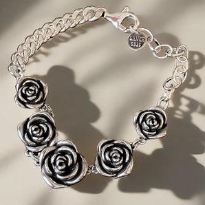 Handcrafted 925 sterling silver rose bracelet with floral charm, showcasing intricate jewelry making and elegant design.