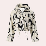 Abstract print women's cropped jacket in black and white with a drawstring waist, featuring a collar and long sleeves.