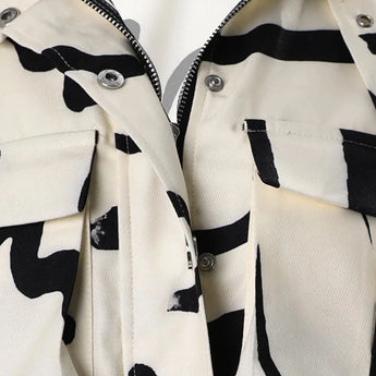 Abstract print women's cropped jacket in black and white featuring a drawstring waist, with a jersey-like texture, long sleeves, and a stylish collar.