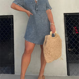 Dark gray acid wash denim mini dress with a collared neck and short sleeves, designed in a trendy style, showcased on a model wearing complementary footwear and eyewear.