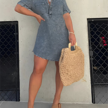 Dark gray acid wash denim mini dress with a collared neck and short sleeves, designed in a trendy style, showcased on a model wearing complementary footwear and eyewear.