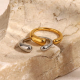 Adjustable minimalist two-tone silver and gold ring with a sleek modern design placed on a beige wooden surface.