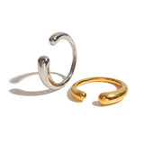 Adjustable minimalist two-tone silver gold ring, sleek modern jewelry on a wooden surface.