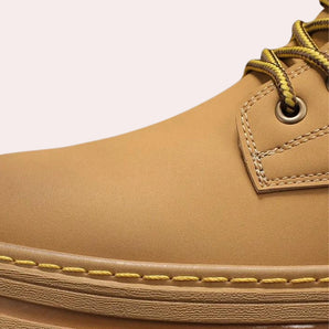 Tan high-top work boots for men made of waterproof leather with metal eyelets and a sturdy sole.