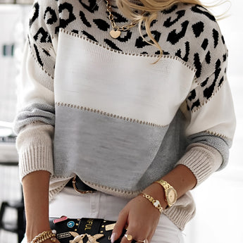 A stylish outfit featuring an animal print sweater, ripped white jeans, lace-up combat boots, and a designer bag.