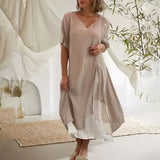 Asymmetrical blue V-neck maxi dress featuring side buttons, displayed on a mannequin showing the shoulder, sleeve, and waist details. The dress is styled for summer fashion and is available in size 4XL in a beige variant.