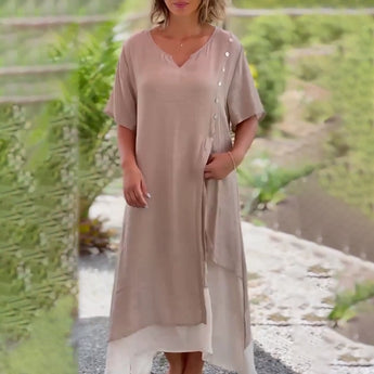 Asymmetrical blue V-neck maxi dress with side buttons, featuring short sleeves and a fitted waist, perfect for summer fashion.