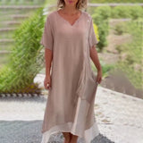 Asymmetrical blue V-neck maxi dress with side buttons, featuring a flowy design, sleeveless style, and cinched waist, suitable for summer fashion.