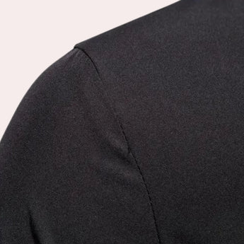 Men's slim fit black shirt with an avant-garde asymmetric design, featuring long sleeves, a collar, and button details, styled with a sleek, modern look.