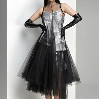 Avant-garde black plaid tulle midi dress featuring an edgy fashion design, showcasing a model wearing the dress with emphasis on the shoulder, sleeve, waist, and thigh areas. The dress is a one-piece garment, styled as a day dress, with a knee-length hem.